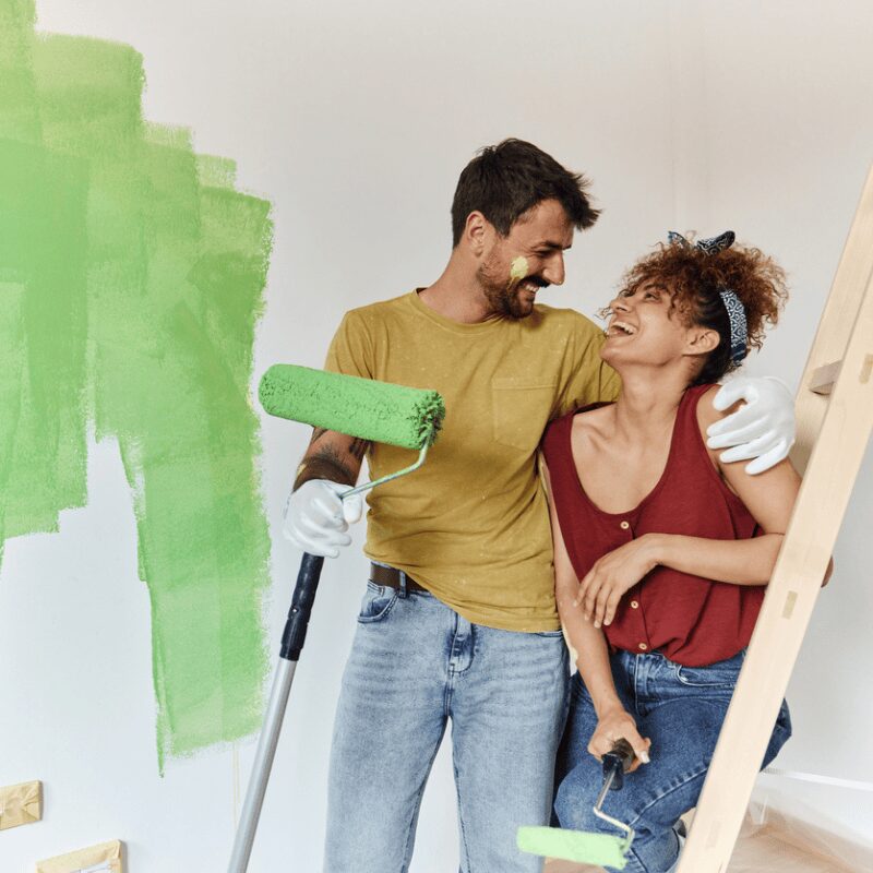 man and woman enjoying painting walls